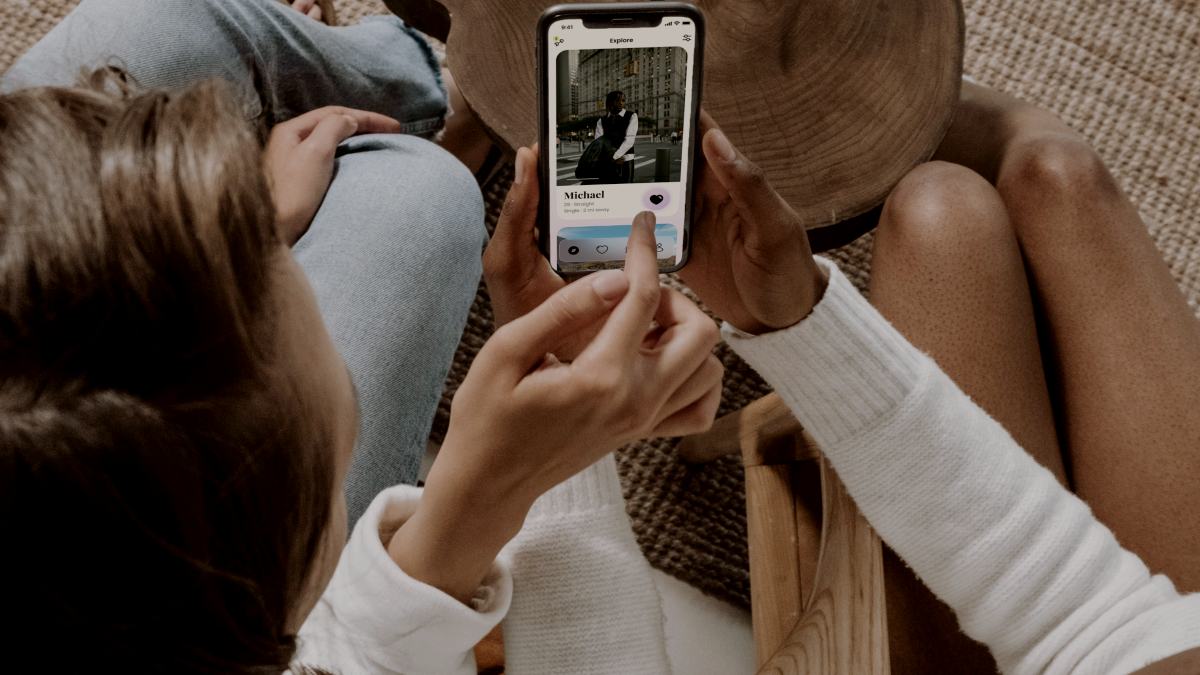 
two women sitting on a couch swiping on an online dating app by Flure Bunny

