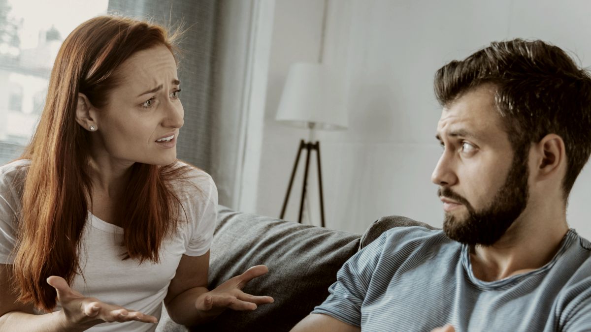 
unhappy young woman looking at her boyfriend and telling him her feelings while being unhappy in their relationships
