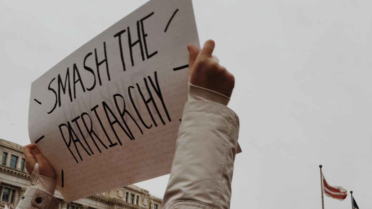 
woman holding white paper with smash the pairtarchy
