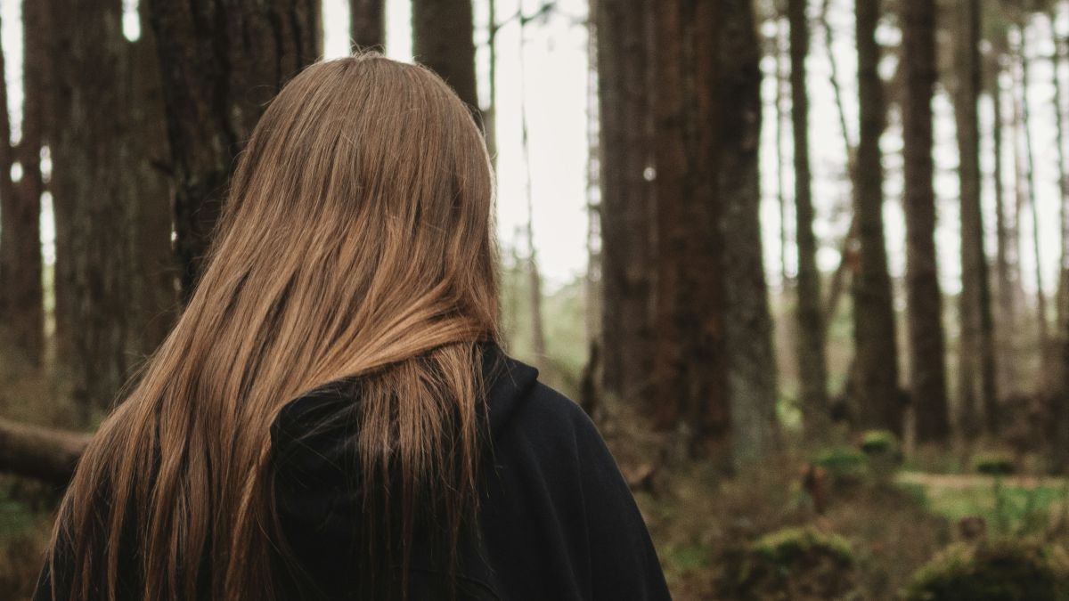
woman in black jacket standing in forest during daytime by Nathan McDine
