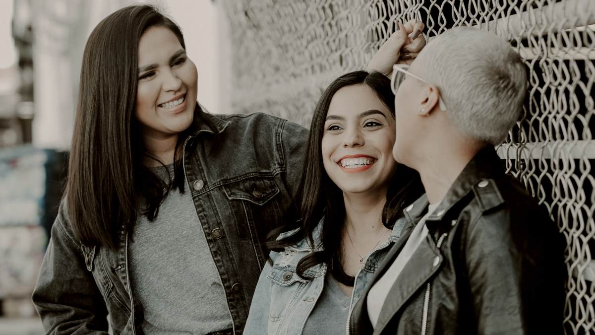 
woman in black leather jacket beside woman in black leather jacket and woman in jean jacket laughing by Joel Muniz
