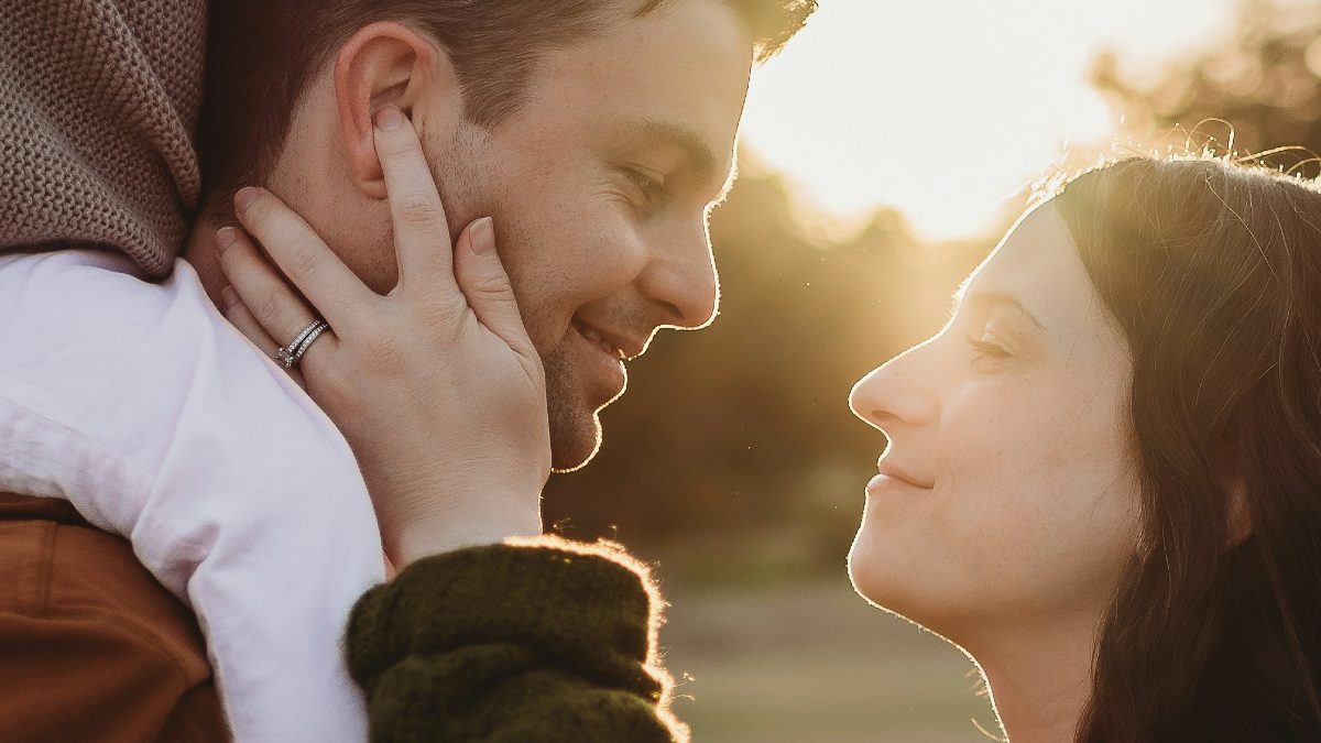 
woman in black sweater holding the face of a man with child on his shoulders by Lauren Samuels
