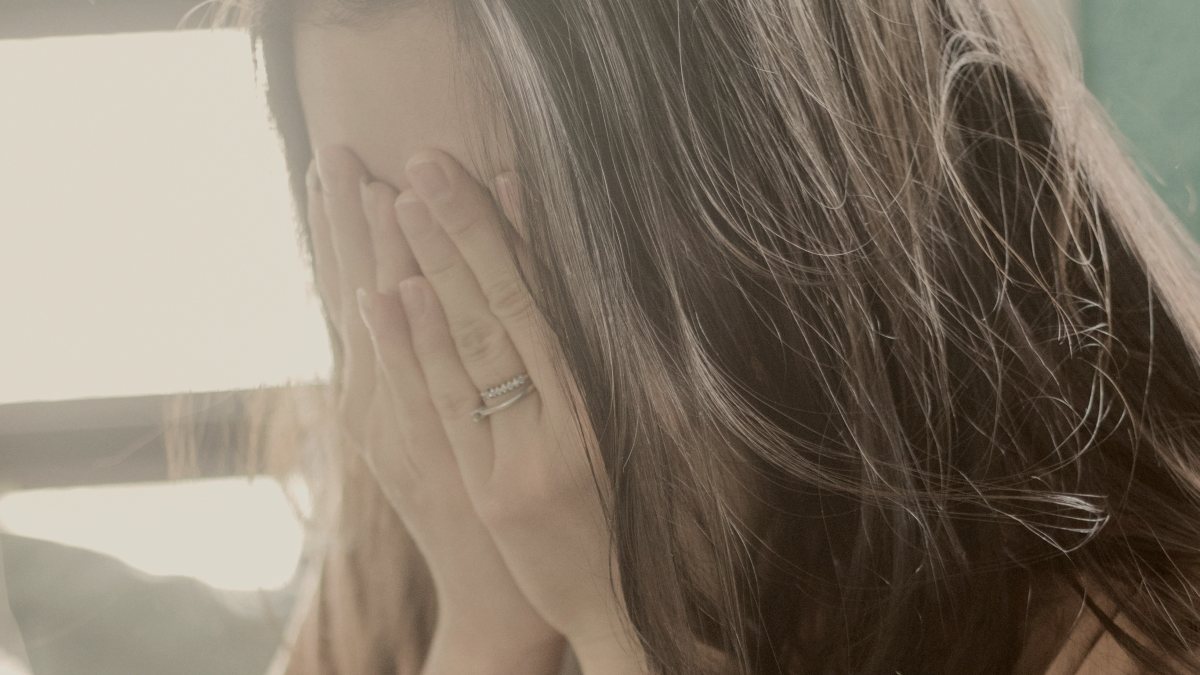 
woman in brown shirt covering her face by Fa Barboza
