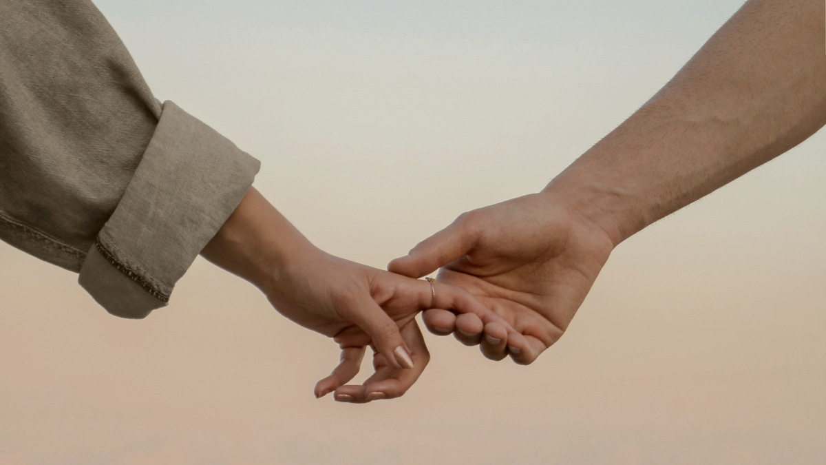 
woman in gray long sleeve shirt holding hands with her partner
