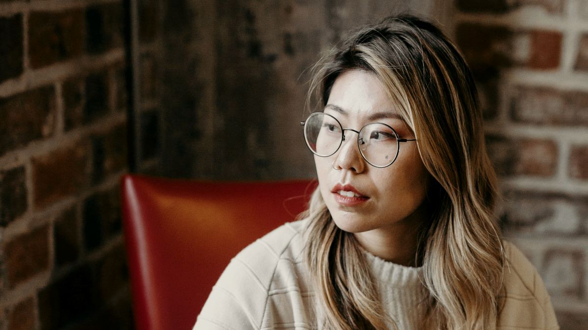 
woman looking sideways while holding black laptop computer
