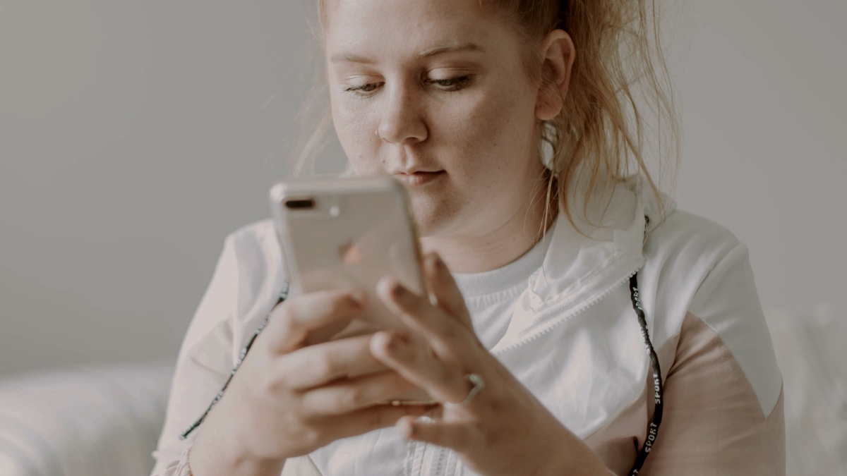 
woman-sitting-on-bed-while-using-gold-turned-8-plus
