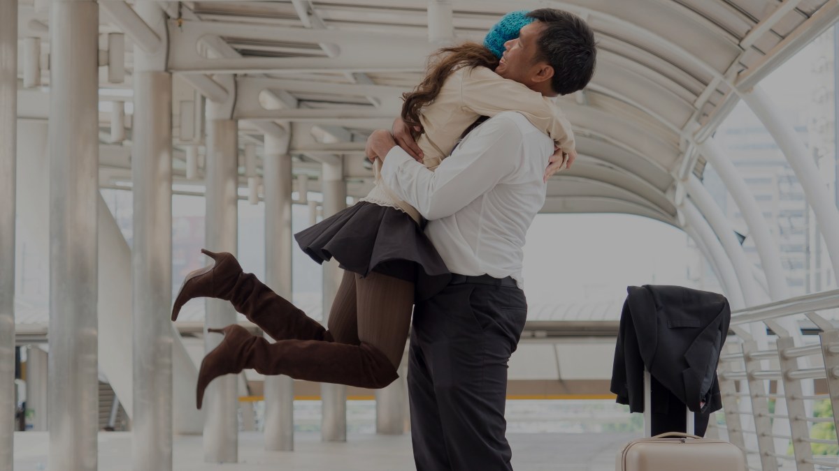 
Woman traveller with suitcase arrival at the airport say hello and hug her husband by getty images
