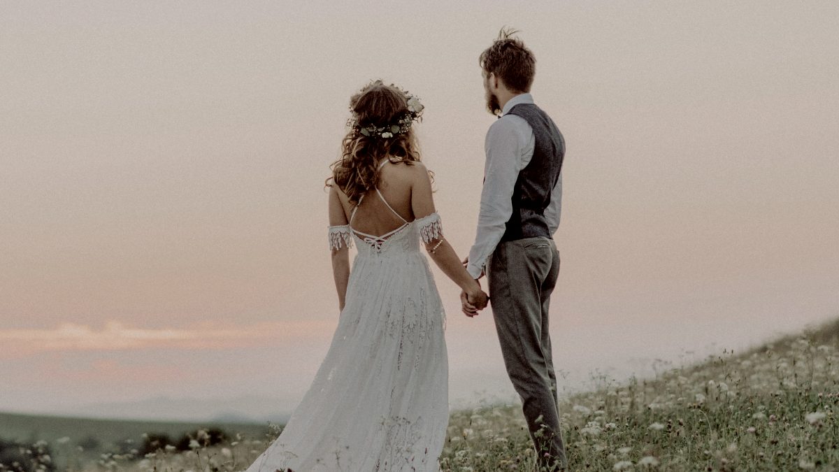 
young-bride-and-groom-outside-in-green-nature-at-romantic-sunset
